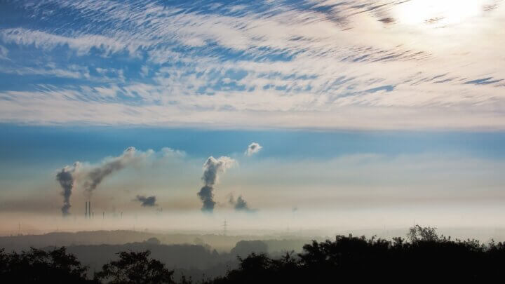 Horizonte com uma indústria poluindo o ar, ignorando a responsabilidade civil ambiental