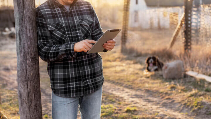 Produtor rural analisando um tablet através do consultivo ambiental